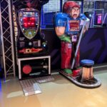 Combo Boxer arcade boxing game with a muscular coach figure and a red LED score display in an arcade.