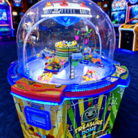 Colorful Treasure Dome arcade prize machine with a clear dome housing spinning toys and blue LED lights.